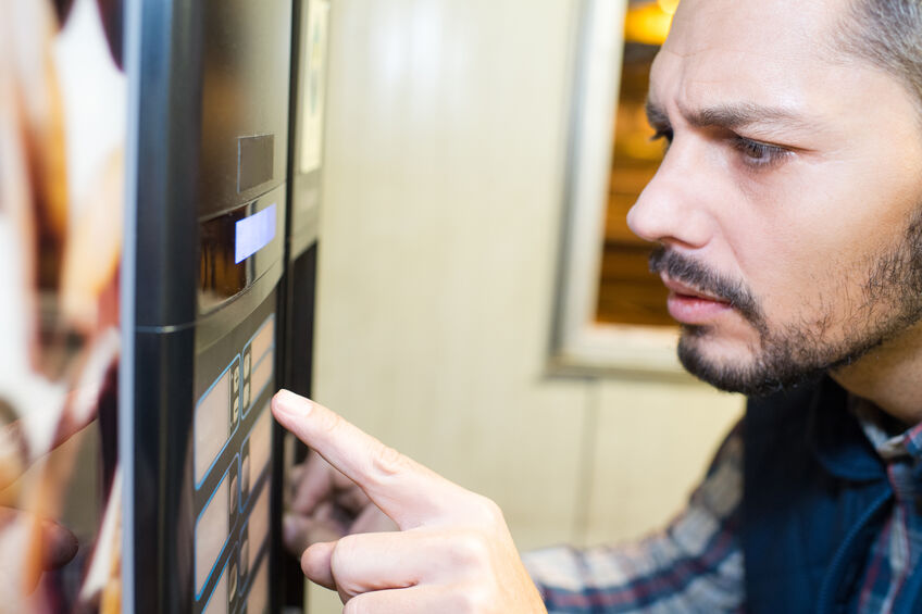 Man having trouble using vending machine