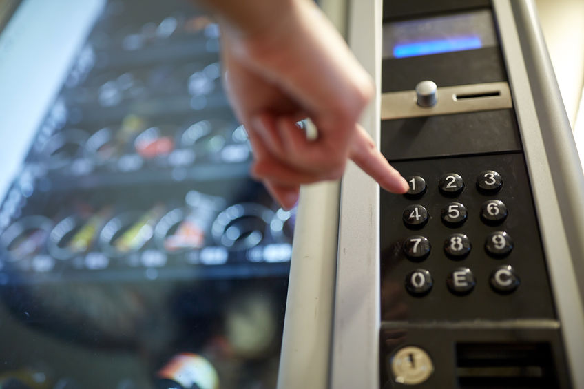 Closeup of woman pushing vending machine buttons